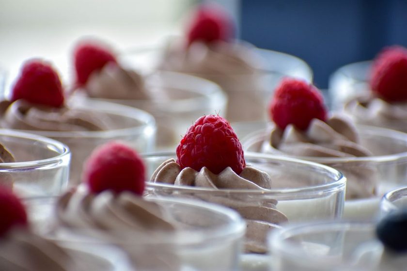 Taça com mousse rosa de frutas vermelhas decorada com frutas frescas